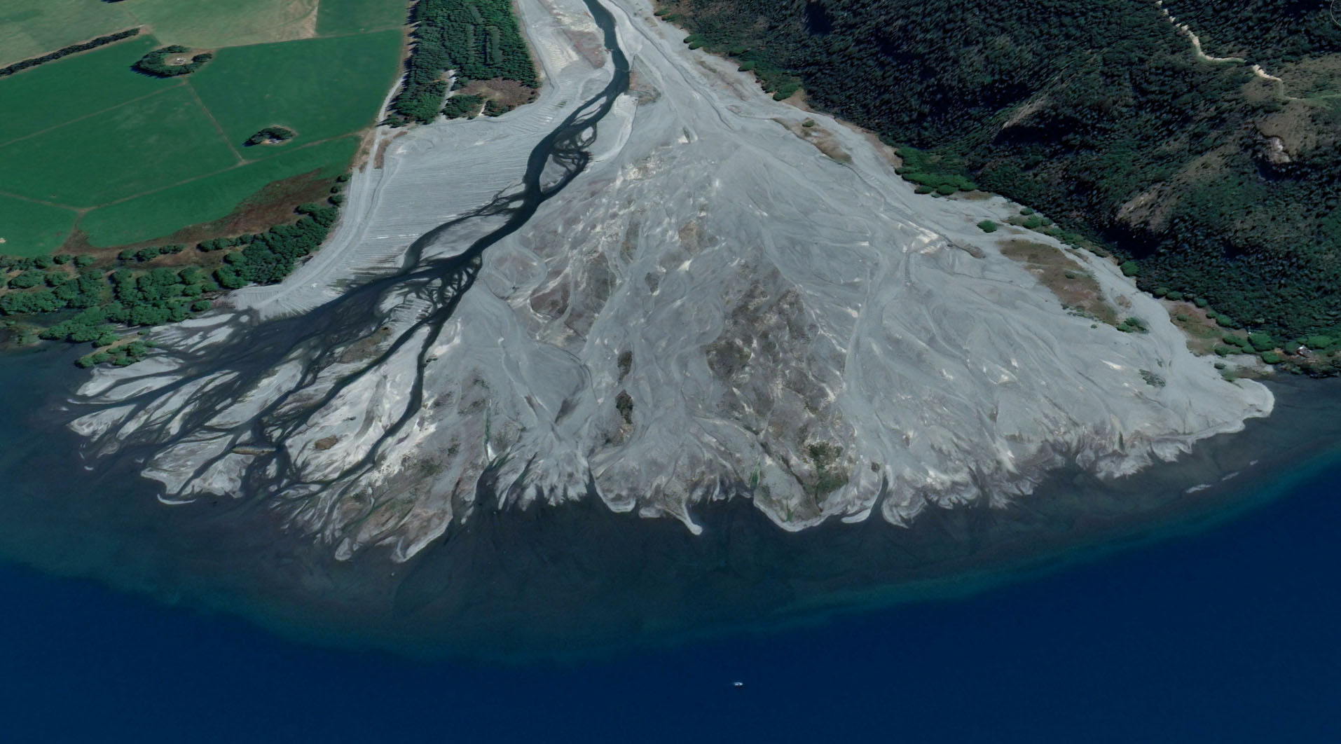 Fig. 4. The Harper River flowing into Lake Coleridge is a good visual analogy of how braided rivers transported sediment from the mountains and deposited it to coastal waters. Over millions of years, as the rivers deposited too much sediment in one place, they changed course to lower-lying areas. Eventually, the land they formed joined into 'megafans', creating what we now call the Canterbury Plains (Image: Google Earth June 2021). Today, braided rivers that have been confined by levees can only deposit these gravels within their confined spaces, eventually building up the riverbed higher than the surrounding land. If the levee breaks during high water flows, an avulsion can happen, leading to widescale flooding with few options to return the water to the river because it's higher than the flooded lands.